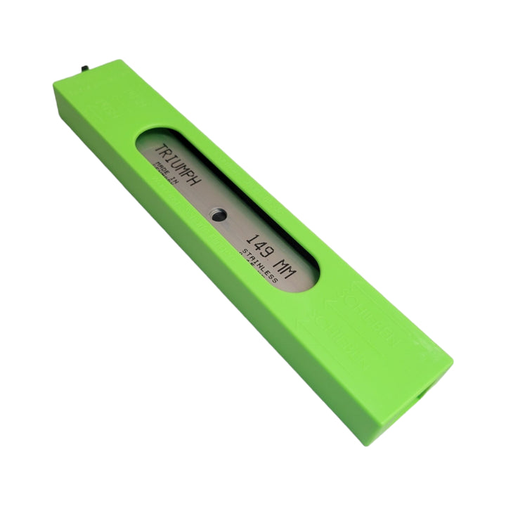 A lime green plastic safety dispenser for scraper blades with a transparent inspection window showing a stainless steel blade marked '0.15 MM Stainless' inside.