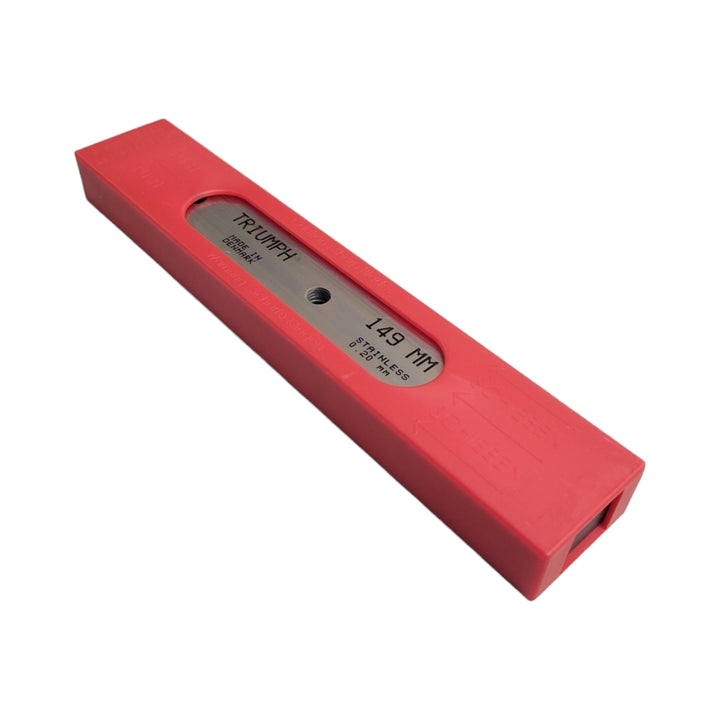 A red plastic safety dispenser for scraper blades, similar to the lime green one, with a slot for dispensing a single blade marked with 'Triumph' branding.