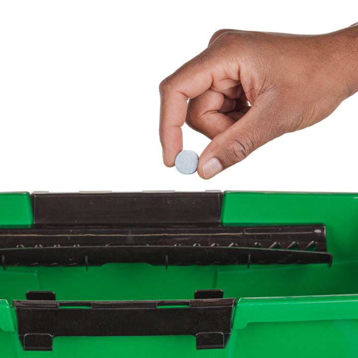 Hand holding an Unger The Pill glass-cleaning tablet above the bucket storage compartment