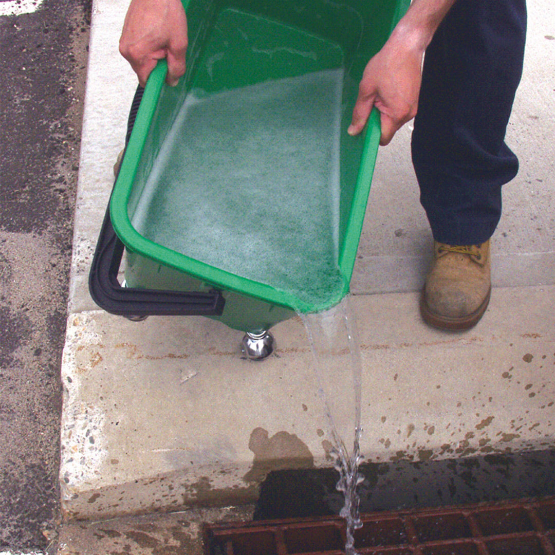 Person draining soapy water from the corner spout of the green Unger window cleaning bucket