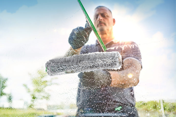 Window cleaner washing exterior glass with an Unger washer and squeegee