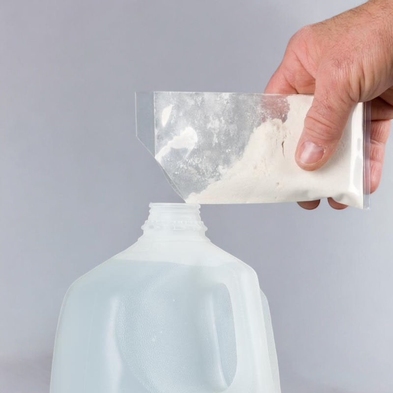 A hand pouring the RO Protect powder from a small clear plastic bag into an empty gallon container, showing the preparation process for use.