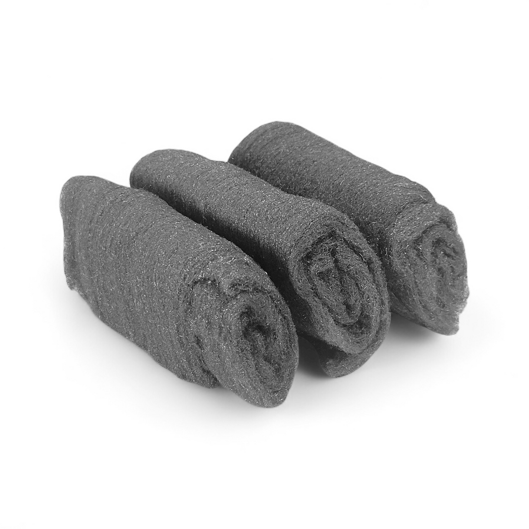3 fine-grade 0000 steel wool pads on a white surface