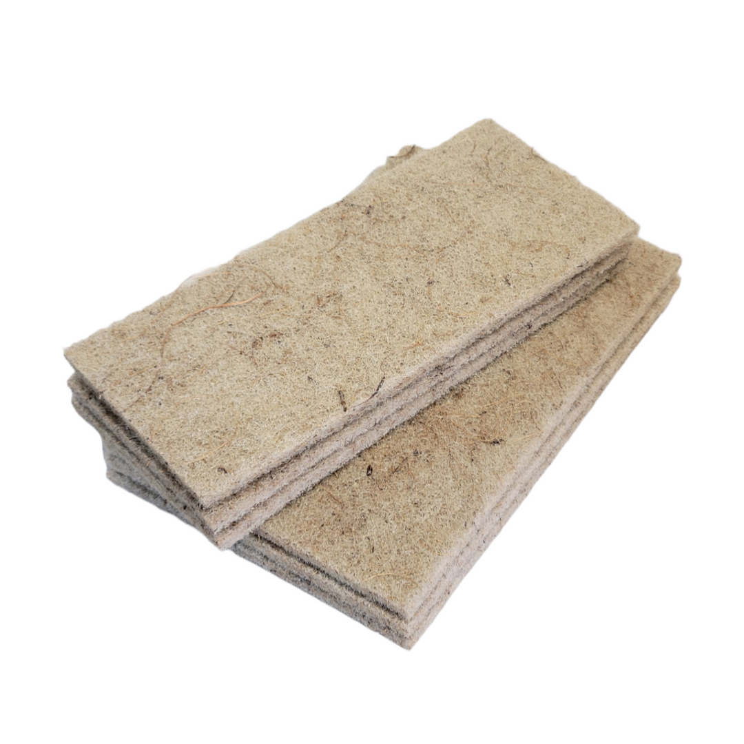 Stack of natural coconut husk scouring pads on a white background, eco-friendly and non-scratch for various surfaces.