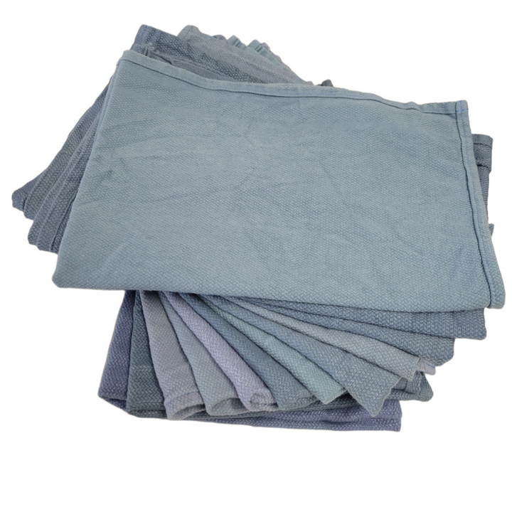 A stack of assorted grey and blue reclaimed surgical towels, showing variation in color and suggesting a multipack offering.